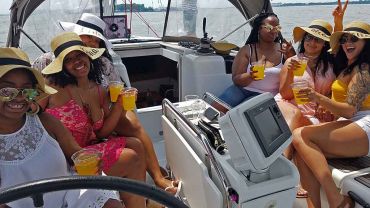Six girls on a sailboat yacht party